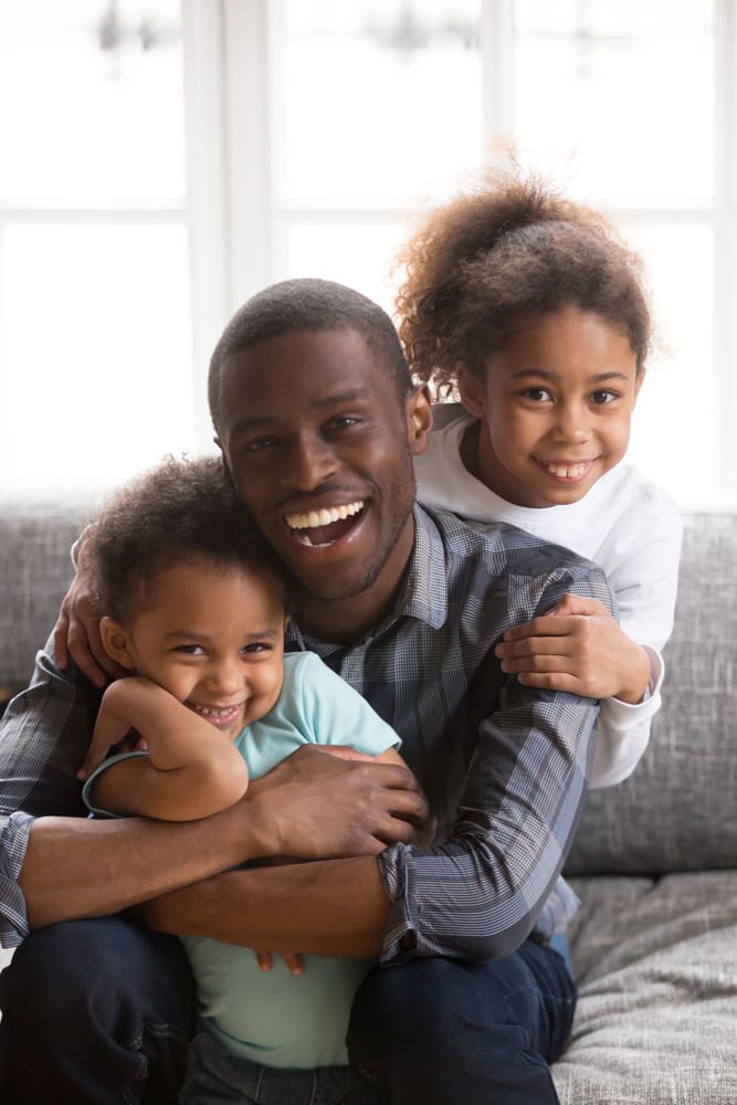 Dad hugging daughters