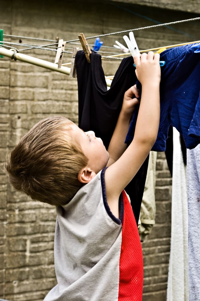 Young hanging clothes on washing line
