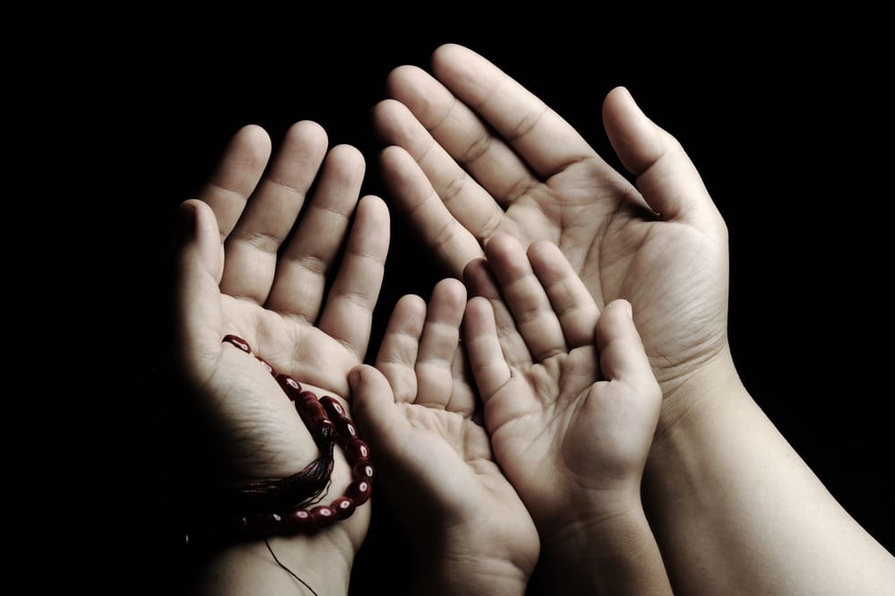Praying and teaching, child and adult praying together parent child's hands making dua