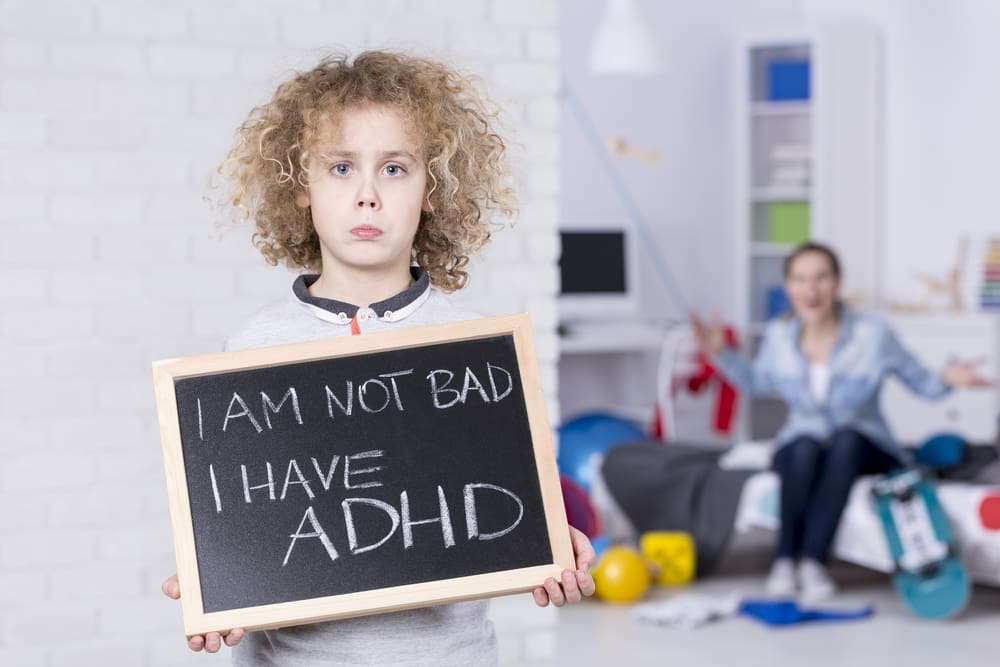 Sad boy holding small board I'm not bad I have ADHD